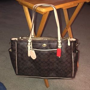 A brown leather Coach diaper bag.